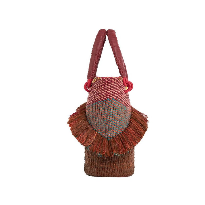 AAKS TIA BLUSH side view detailing handcrafted raffia tote bag with leather wrapped handles features  weavings of soft pink, maroon, yellow, tan, earth with turquoise