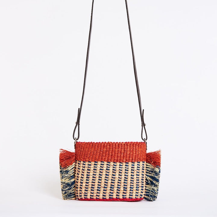 AAKS handcraft woven raffia bag in mini size with body crossover leather strap. Bright orange red detailed with natural and blue weaves and side detailing 