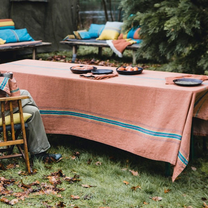Libeco Belgian linen tablecloth, The Ontario Stripe, stunning classic table linen fabric in a pure linen herringbone with the green, blue, yellow, black multi-colored stripes sit on a terracotta ground.