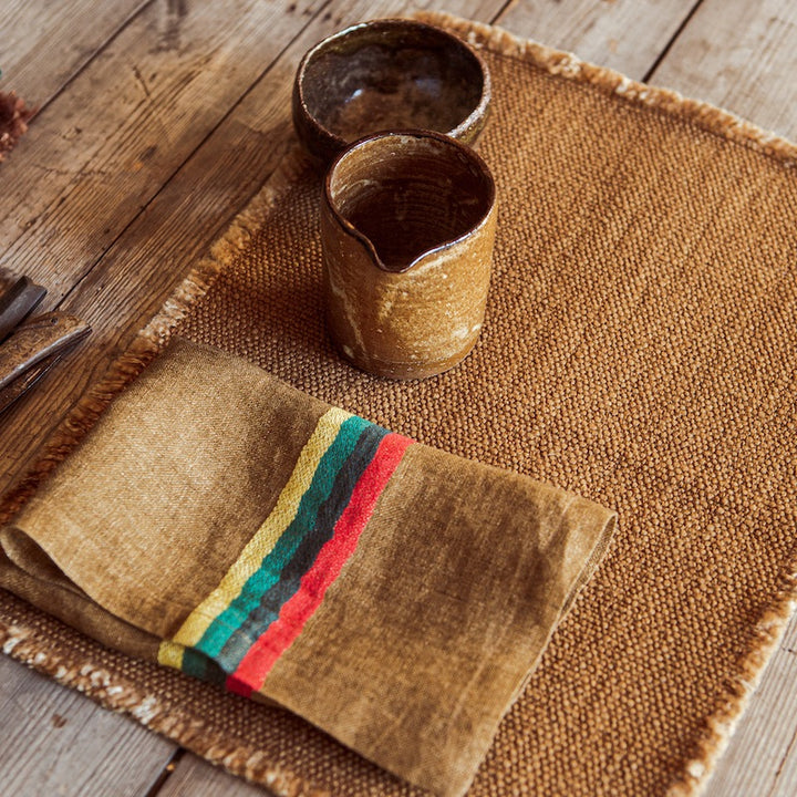 This open weave napkin is modish and soft to the touch. Ginger-colored ground with stripes in red, blue, green and mustard, Yukon is a stylish napkin that beautifies your table setting and culinary design splendidly.  From rustic European country style to modern high design, the high art of the textile brings out sensations of joy and comfort.