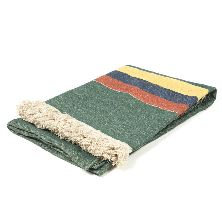 Folded Libeco Belgian linen throw Spruce that has a green ground with stripes in gold, navy, and mahogany with flax-colored fringe.