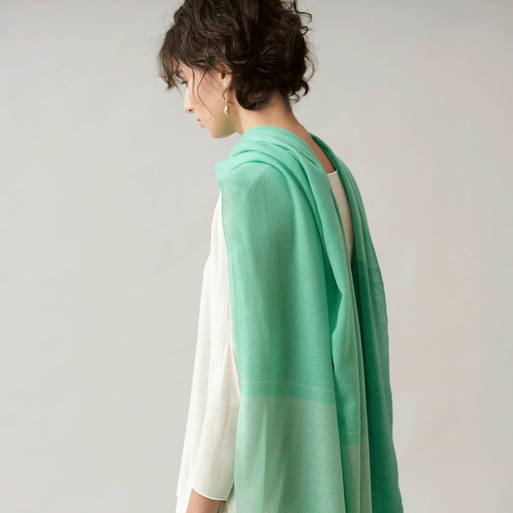 Woven by hand loom in Terrassa (Barcelona), using the supreme delicacy of cashmere fibre, design by Helena Rohner for Teixidors is the finest Italian cashmere is Nuance  - the model is wearing Seafoam color draped elegantly